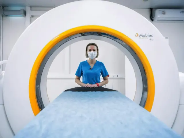 Lekarz rodzinny może wystawić skierowanie na rezonans. W gabinecie stoi technik medyczny przy aparacie do rezonansu magnetycznego.