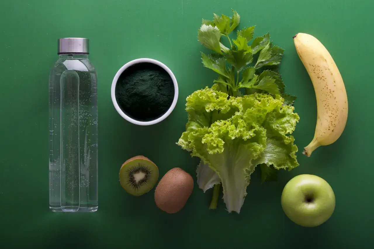 Butelka wody, spirulina, kiwi, sałata, seler, banan i jabłko – składniki wspierające walkę z zatrzymaniem wody w organizmie.